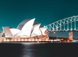 Stunning night view of Sydney Opera House and Harbour Bridge, beautifully illuminated against a clear sky.