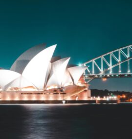 Stunning night view of Sydney Opera House and Harbour Bridge, beautifully illuminated against a clear sky.